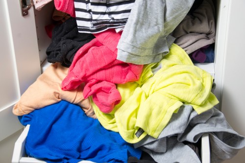 Workers loading waste into a van in a busy Brixton street market area